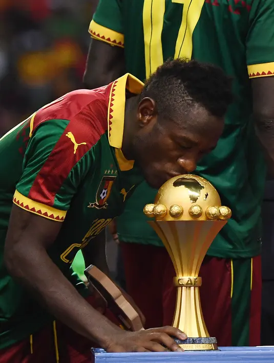 Gelandang Kamerun Christian Bassogog mencium piala saat merayakan kemenangan atas Mesir pada laga final Piala Afrika 2017 di Stade de I'Amitie, Gabon, Minggu (5/2). Kamerun juara Piala Afrika 2017 setelah menaklukkan Mesir dengan skor. (GABRIEL BOUYS/AFP)