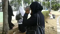Guru honorer dari SDN Bojongnangka 04 Kecamatan Gunung Putri, Kabupaten Bogor, Umi Hasanah ketinggalan rombongan demo di depan Gedung DPR/MPR karena menyempatkan untuk mengajar. (Liputan6.com/Audrey Santoso)