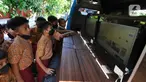 Siswa SDN Kemirimuka 2 Depok menggunakan internet sehat pada Operator Mobile Community Acces Point (M-CAP) di  Depok, Jawa Barat, Kamis (28/7/2022). Sosialisasi yang dilakukan Dinas Komunikasi dan Informatika (Diskominfo) itu dalam rangka pengenalan perangkat komputer, pemakaian program aplikasi microsoft word dan mencari Informasi menggunakan internet sehat untuk belajar. (merdeka.com/Arie Basuki)