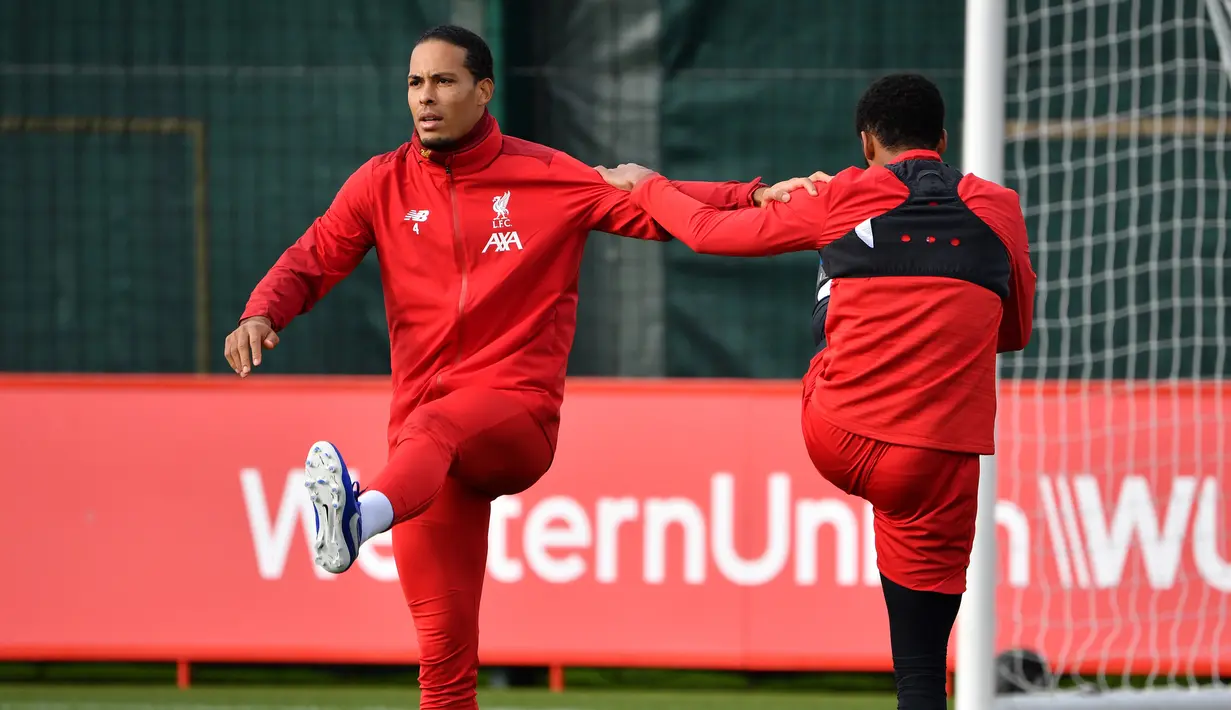 Bek Liverpool, Virgil van Dijk (kiri) melakukan pemanasan selama mengikuti sesi latihan tim di Melwood di Liverpool, Inggris barat laut (22/10/2019). Liverpool akan bertanding melawan wakil Belgia, Genk pada Grup E Liga Champions di Luminus Arena. (AFP/Paul Ellis)