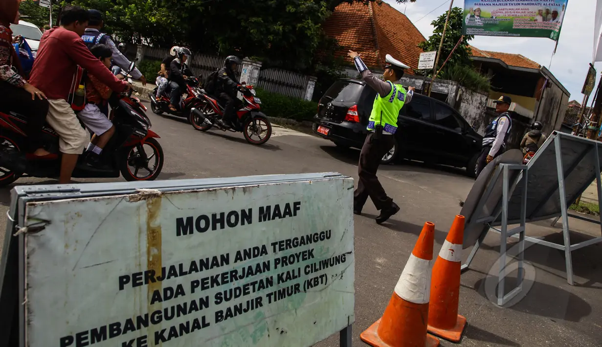 Petugas mengatur lalu lintas di jalan yang terkena pengalihan arus di kawasan Otista, Jakarta, Kamis (23/4). Jalan Otto Iskandardinata 3 akan ditutup selama 70 hari karena pembangunan sodetan Kali Ciliwung kembali dilanjutkan. (Liputan6.com/Faizal Fanani)