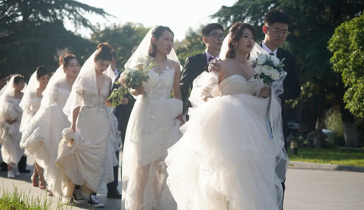 Beberapa pasangan pengantin bersiap untuk berfoto di Nanjing, Provinsi Jiangsu, China timur, (19/5/2020). Di antara pasangan pengantin baru itu terdapat beberapa pekerja medis yang menunda pernikahan mereka karena ikut berjuang memerangi pandemi COVID-19. (Xinhua/Ji Chunpeng)
