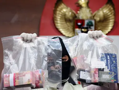 Petugas menunjukkan barang bukti hasil OTT kasus dugaan penyuapan pembahasan perda penyertaan modal Kota Banjarmasin ke PDAM di Gedung KPK, Jakarta, Jumat (15/9). KPK memeriksa empat orang diduga tersangka. (Liputan6.com/Helmi Fithriansyah)