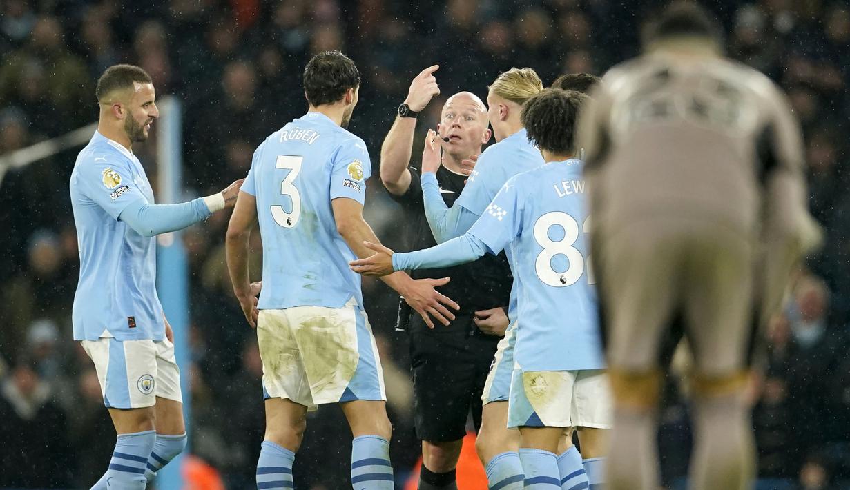 Wasit Simon Hooper (tengah) memberikan penjelasan kepada sejumlah pemain Manchester City saat laga pekan ke-14 Liga Inggris 2023/2024 melawan Tottenham Hotspur yang berlangsung di Etihad Stadium, Manchester, Inggris, Senin (04/12/2023) dini hari WIB. (AP Photo/Dave Thompson)