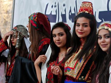 Sejumlah model menunggu giliran saatm mengikuti peragaan busana tradisional Palestina di Kota Tua Nablus, Tepi Barat, Palestina, Selasa (22/8). Peragaan busana ini sebagai salah satu upaya untuk melestarikan budaya Palestina. (AFP Photo/Jaafar Ashtiyeh)