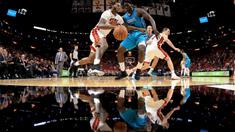 Pebasket Miami Heat, James Johnson (kiri) mencoba melewati adangan pebasket Hornets, Johnny O'Bryant III #8  pada laga NBA pre-season di American Airlines Arena, Miami, (9/10/2017). Miami Heat menang 109-106. (Mike Ehrmann/Getty Images/AFP)