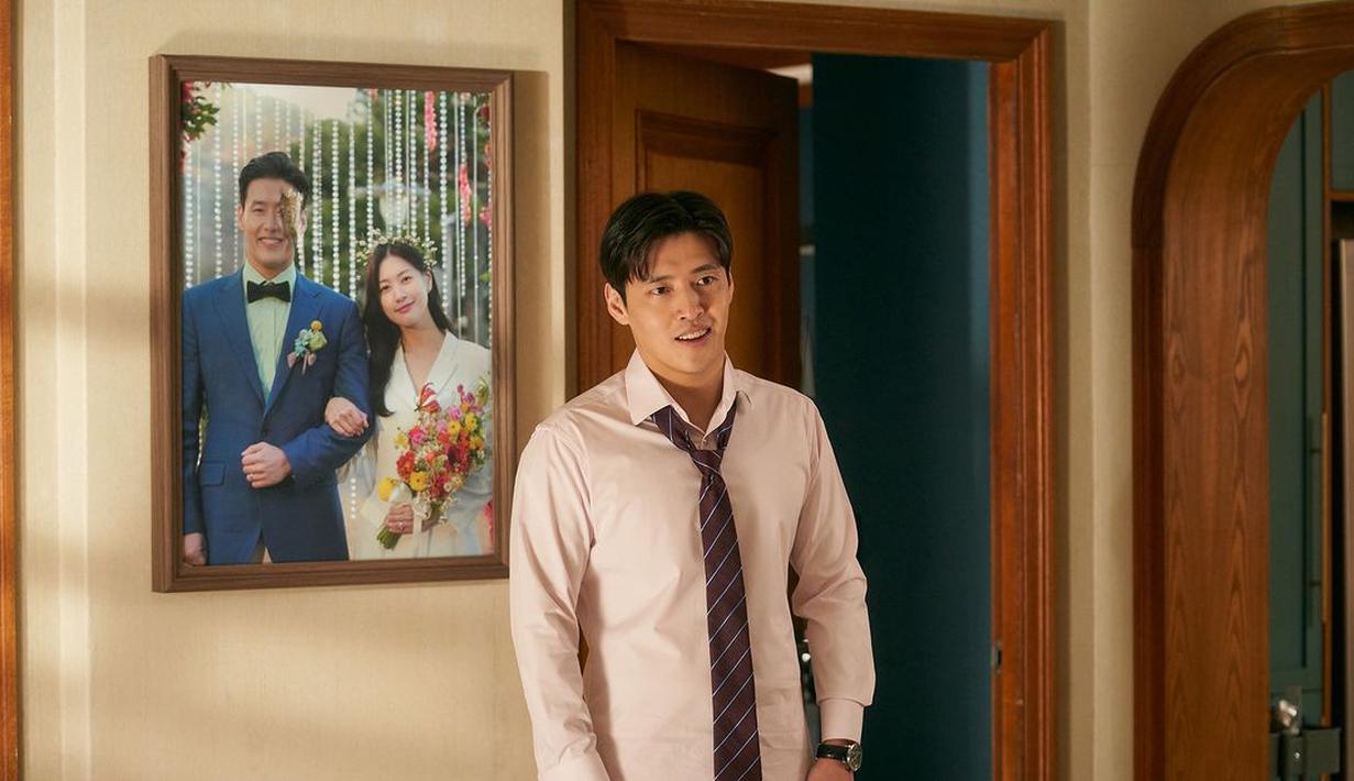 Pemirsa dapat melihat sekilas kehidupan pernikahan Jung Yeol dan Na Ra yang sulit saat mereka saling memandang dari kejauhan dengan latar belakang foto pernikahan mereka yang sebagian dirobek. (Foto: Mindmark via Soompi)