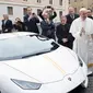 Paus Fransiskus saat menerima hadiah mobil Lamborghini Huracan di Vatikan, Rabu (15/11). Mobil Lamborghini ini oleh Paus rencananya akan dilelang dan hasilnya akan digunakan untuk membantu jemaah Kristen di Irak. (L'Osservatore Romano/Pool Photo via AP)