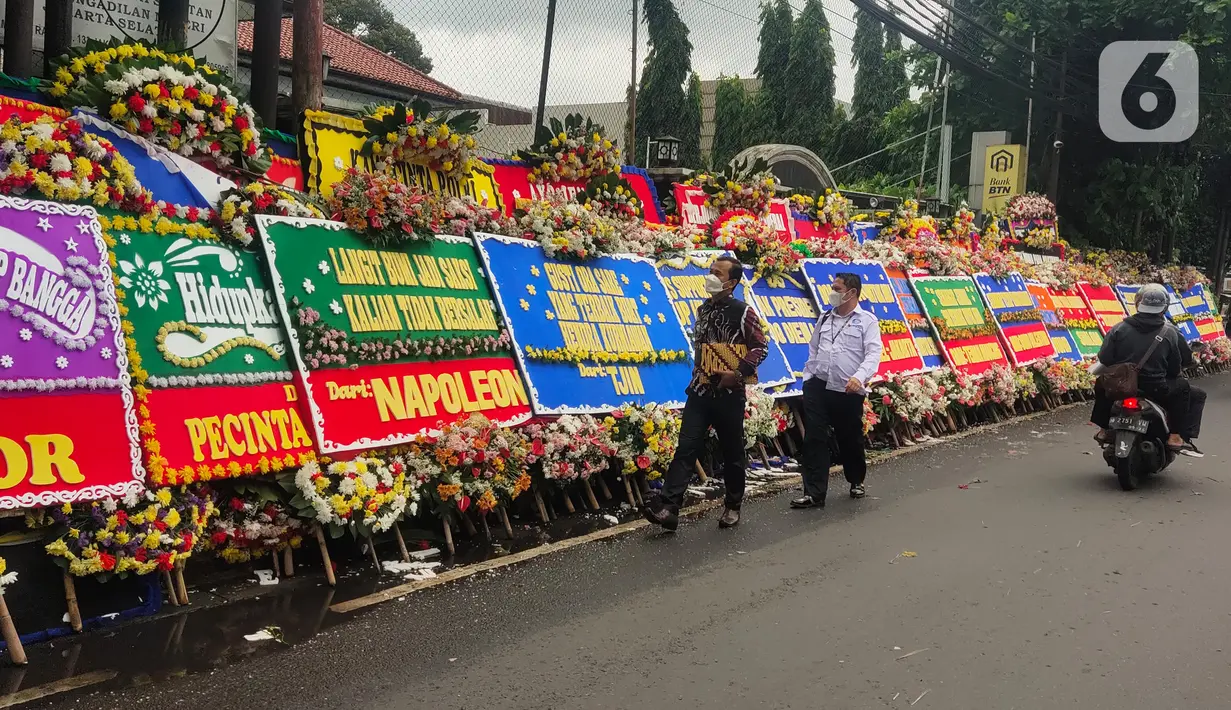 Pengguna jalan melintasi karangan bunga untuk terdakwa  kasus obstruction of justice perintangan penyidikan tewasnya Brigadir J, Hendra Kurniawan di depan Pengadilan Negeri Jakarta Selatan, Senin (27/2/2023). Berbagai ucapan serta dukungan datang dari sejumlah elemen masyarakat untuk Hendra Kurniawan akan menjalani sidang vonis kasus perintangan penyidikan kematian Nofriansyah Yosua Hutabarat alias Brigadir J. (Liputan6.com/Angga Yuniar)