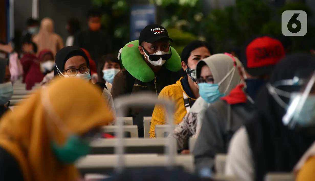 Calon penumpang menunggu keberangkatan kereta di Stasiun Senen, Jakarta, Jumat (25/12/2020). Petugas KAI yang mengenakan kostum Natal membagikan masker kepada calon penumpang untuk memutus mata rantai penyebaran COVID-19 saat mudik Natal dan Tahun Baru 2021. (merdeka.com/Imam Buhori)