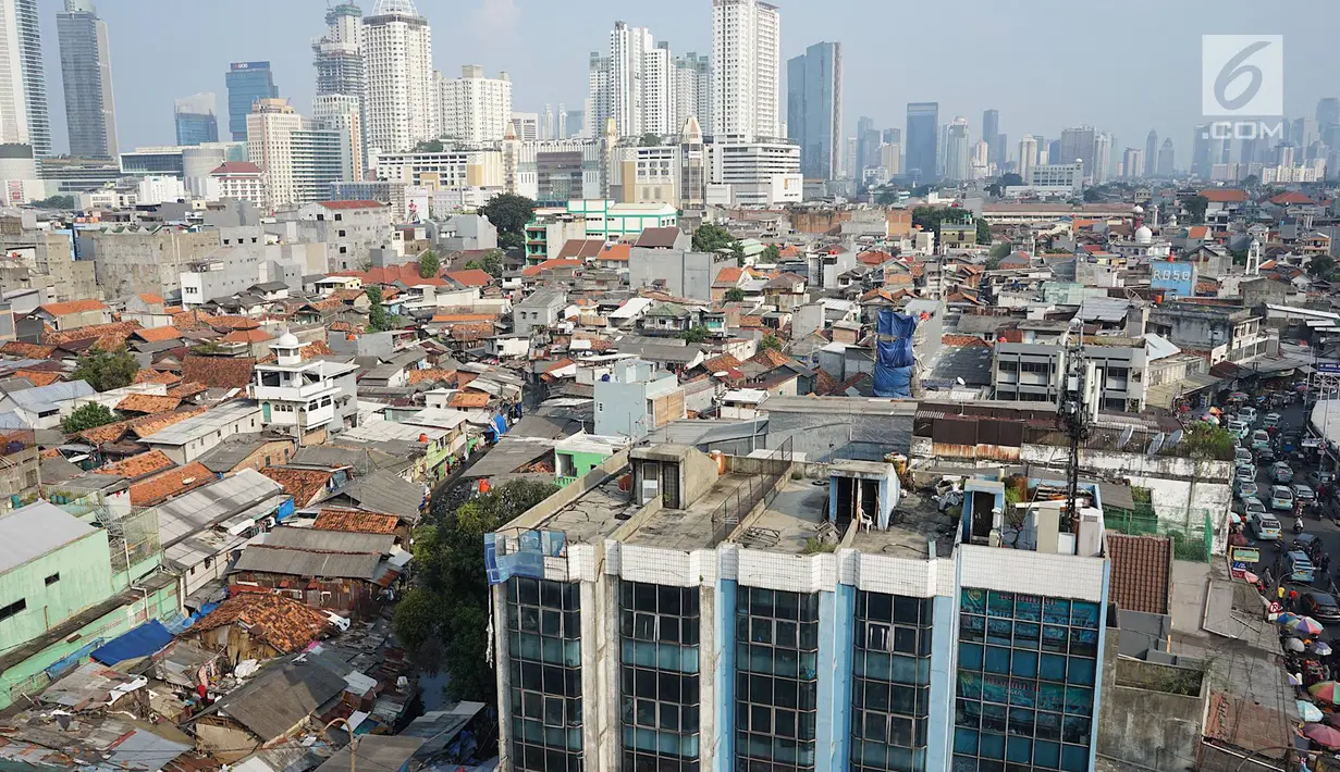 Lansekap pemukiman penduduk berlatar gedung bertingkat terlihat dari Tanah Abang, Jakarta, Selasa (21/5). Laporan Oxford Economics berjudul Global Cities 2018 menyebut Jakarta akan jadi kota dengan jumlah penduduk terbesar di dunia pada 2035, yakni 38 juta jiwa. (Liputan6.com/Immanuel Antonius)