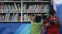 Seorang anak membaca buku di mobil Perpustakaan Keliling di Klungkung, Bali, Sabtu (30/09). Perpustakaan Keliling ini hadir untuk memberikan hiburan bagi korban Gunung Agung khususnya anak-anak.  (Liputan6.com/Gempur M Surya)