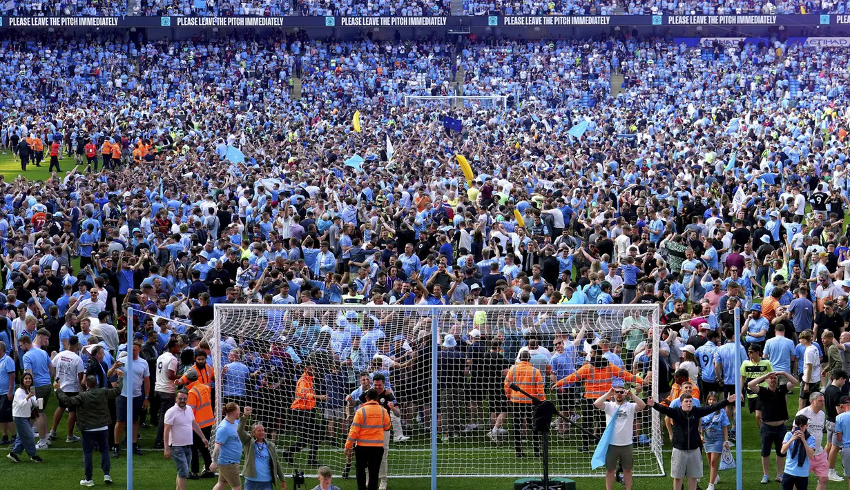 Para suporter memasuki lapangan setelah berakhirnya laga antara Manchester City menghadapi Chelsea pada laga lanjutan pekan ke-37 Liga Inggris 2022/2023 di Etihad Stadium, Manchester (21/5/2023). (AP Photo/Jon Super)