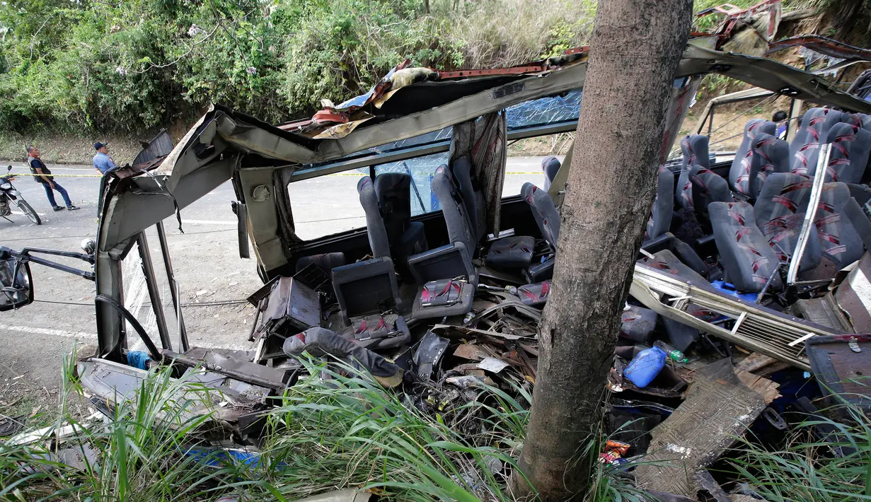 Petugas memeriksa tempat terjadinya kecelakaan, Tanay, Filipina, Senin (20/2). Empat belas orang tewas yang terdiri dari 13 pelajar dan seorang lagi adalah sopir bus tersebut. (AP Photo / Aaron Favila)