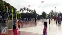 Sejumlah anak bermain layang layang di Lapangan Monumen Tugu Pancasila TMII, Jakarta, Jumat (8/7). TMII masih menjadi lokasi favorit warga menghabiskan libur hari raya. (Liputan6.com/Helmi Fithriansyah)