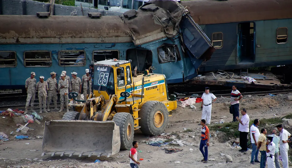 Petugas keamanan setempat berjaga disekitar lokasi tabrakan kereta di Kota Alexandria, Mesir (11/8). Akibat tabrakan dua kereta tersebut, sedikitnya 36 orang tewas dan 123 orang lainnya menderita luka. (AP Photo/Ravy Shaker)