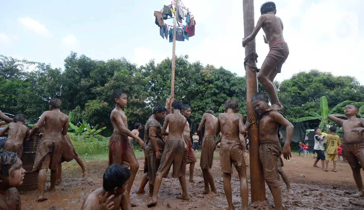 Sejumlah peserta bahu-membahu dalam perlombaan panjat pinang di Kampung Bulak, Kelurahan Benda Baru, Pamulang, Tangerang Selatan, Senin (17/8/2020). Lomba di tengah masa pandemi itu guna memeriahkan HUT ke-75 Kemerdekaan RI. (merdeka.com/Dwi Narwoko)