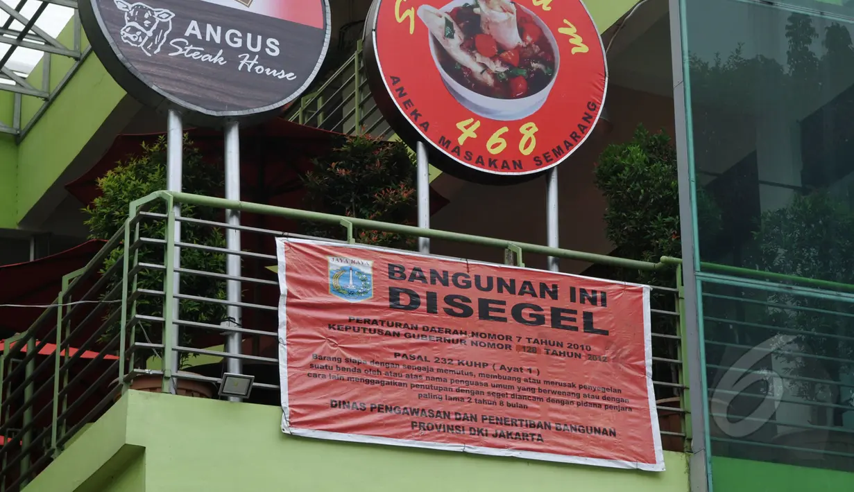 Sebuah spanduk segel terpampang di pagar Mall Jatinegara Xtaiment, Jakarta, Senin (13/4/2015). (Liputan6.com/Johan Tallo) 