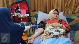 Seorang wanita melakukan donor darah di kawasan Senayan, Jakarta, Rabu (13/4). Dalam kegiatan tersebut Senayan City juga mengkampanyekan gaya hidup sehat dengan olahraga. (Liputan6.com/Herman Zakharia)