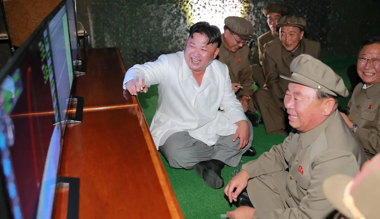 Pemimpin Korut, Kim Jong-un bersama pasukannya melihat monitor saat tes tembakan rudal balistik dari kapal selam, Pyongyang (25/8). Peluncuran rudal disinyalir sebagai bentuk protes atas latihan militer gabungan Korsel-AS. (REUTERS/KCNA)