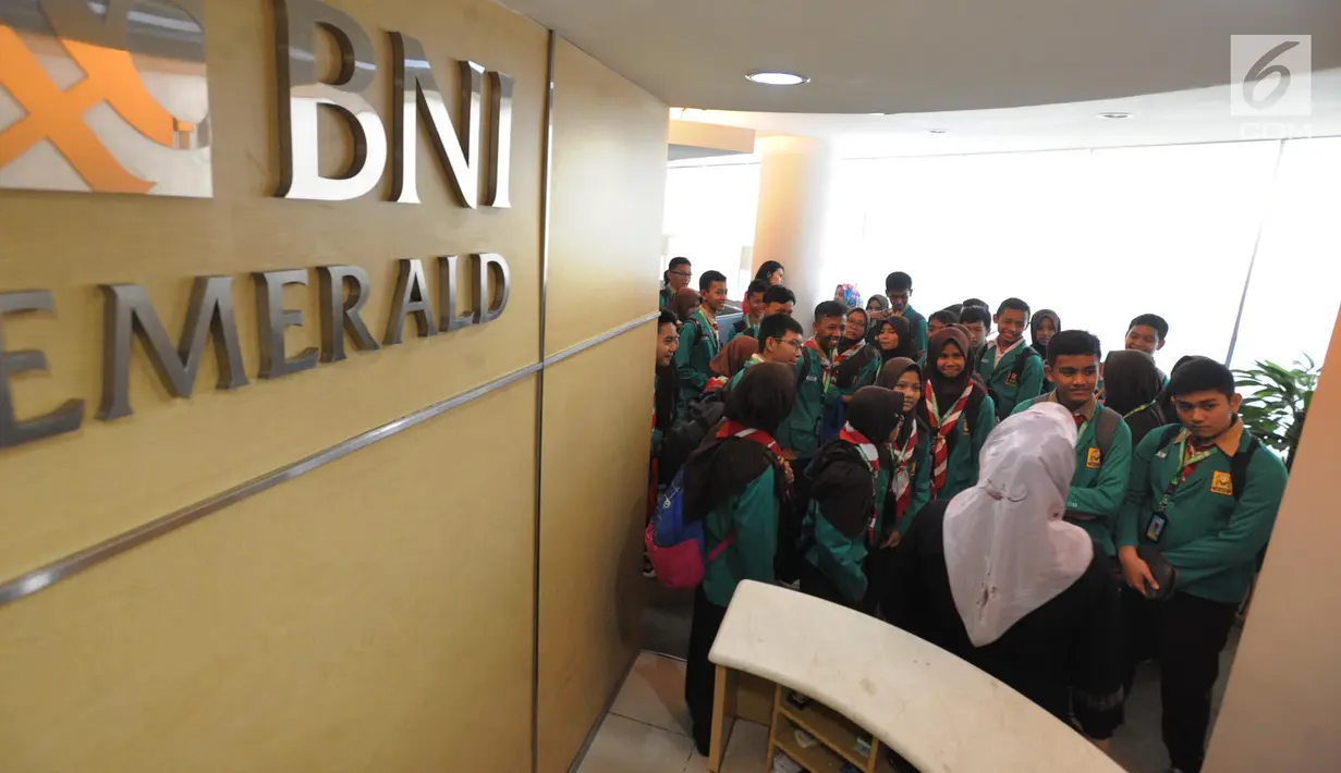 Para siswa mendengar penjelasan karyawan BNI saat berkunjung ke BNI Kantor Cabang Tebet, Jakarta (2/5). (Merdeka.com/Arie Basuki)