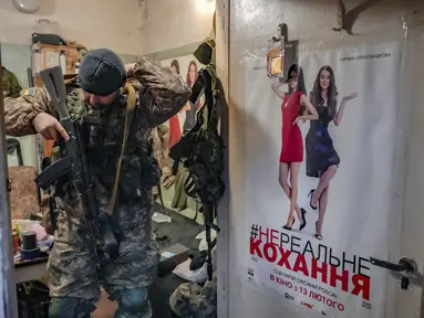 Seorang anggota pertahanan teritorial bersiap untuk berpatroli dari ruang teknis di bioskop di Kyiv, Ukraina, Senin (7/3/2022). Ukraina mengklaim lebih dari 11.000 tentara Rusia tewas dalam perang antara Rusia-Ukraina sejak 24 Februari 2022 lalu. (AP Photo/Vadim Ghirda)