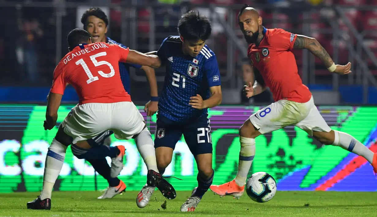 Gelandang Jepang, Takefusa Kubo (tengah) berusaha melewati dua pemain Chile, Jean Beausejour dan Arturo Vidal selama pertandingan grup C Copa America 2019 di Stadion Morumbi, Sao Paulo, Brasil (17/6/2019). Kubo merupakan remaja 18 tahun yang dijuluki 'Messi Jepang'. (AFP Photo/Nelson Almeida)
