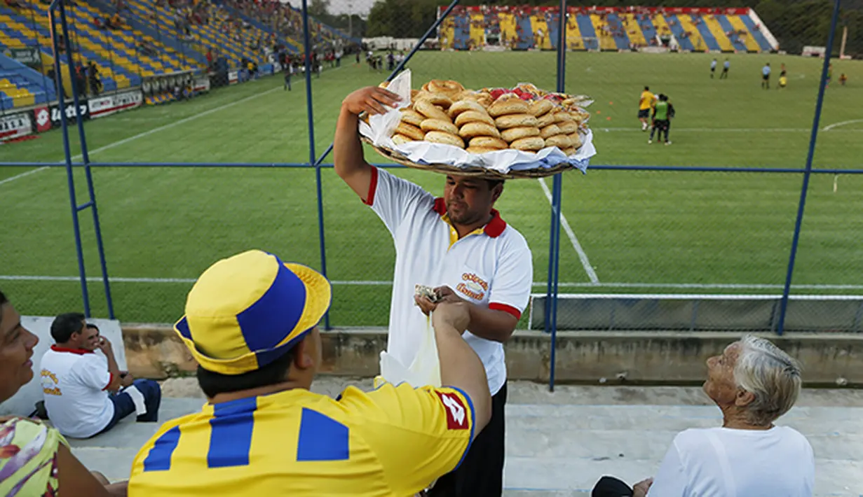 Pedagang kue tradisional khas Paraguay bernama Chipa menjajakan dagangan dengan bebas di stadion kandang Deportivo Capiata. (AP Photo/Jorge Saenz) 