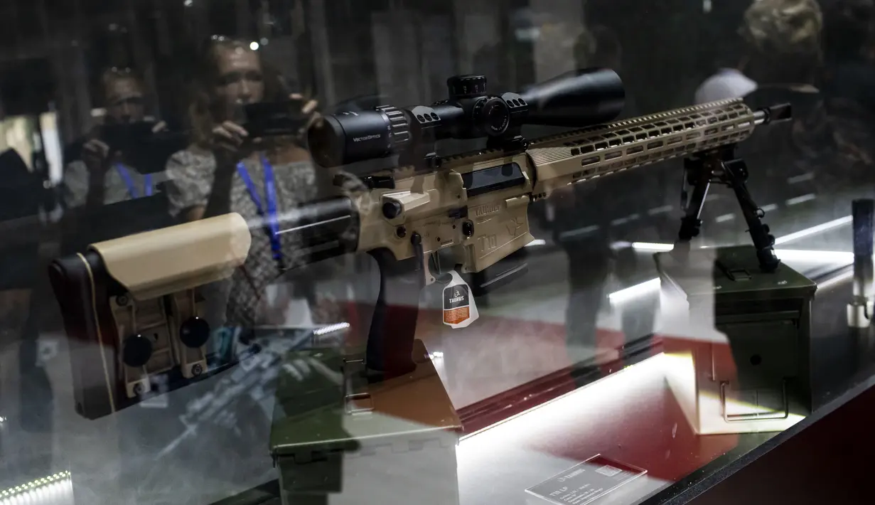 Tercermin dalam kaca, seorang pengunjung memotret senapan T10 LP yang dipajang di Pameran Internasional Pertahanan dan Keamanan LAAD 2023. (AP Photo/Bruna Prado)