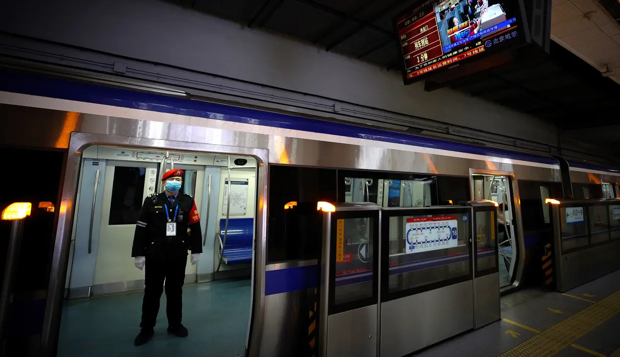 Petugas keamanan mengenakan masker saat berdiri di kereta bawah tanah di Beijing, China, Senin (17/2/2020). Wabah virus corona atau COVID-19 membuat warga kota berpopulasi 21,5 juta jiwa ini tidak banyak beraktivitas di luar rumah. (AP Photo/Andy Wong)