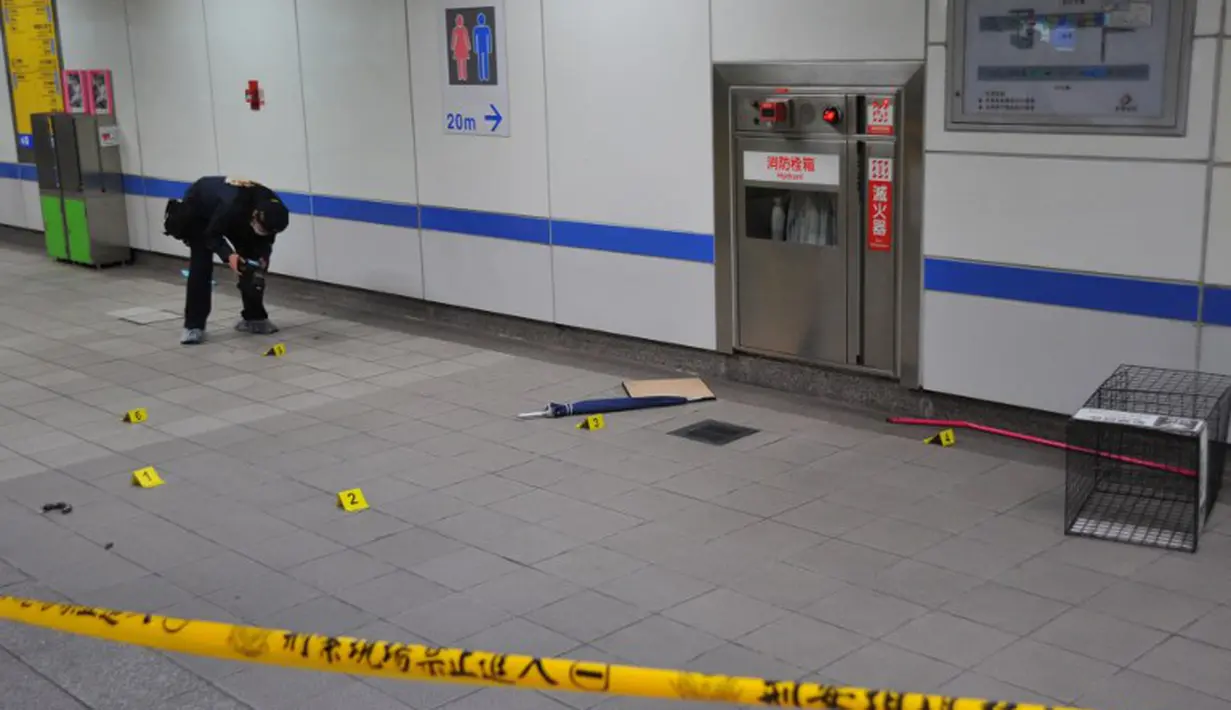 Seorang petugas melakukan oleh tempat kejadian perkara (TKP) insiden penusukan di stasiun Taipei Metro di Taipei, Taiwan, Rabu (21/5/14). (AFP PHOTO/Mandy Cheng)
