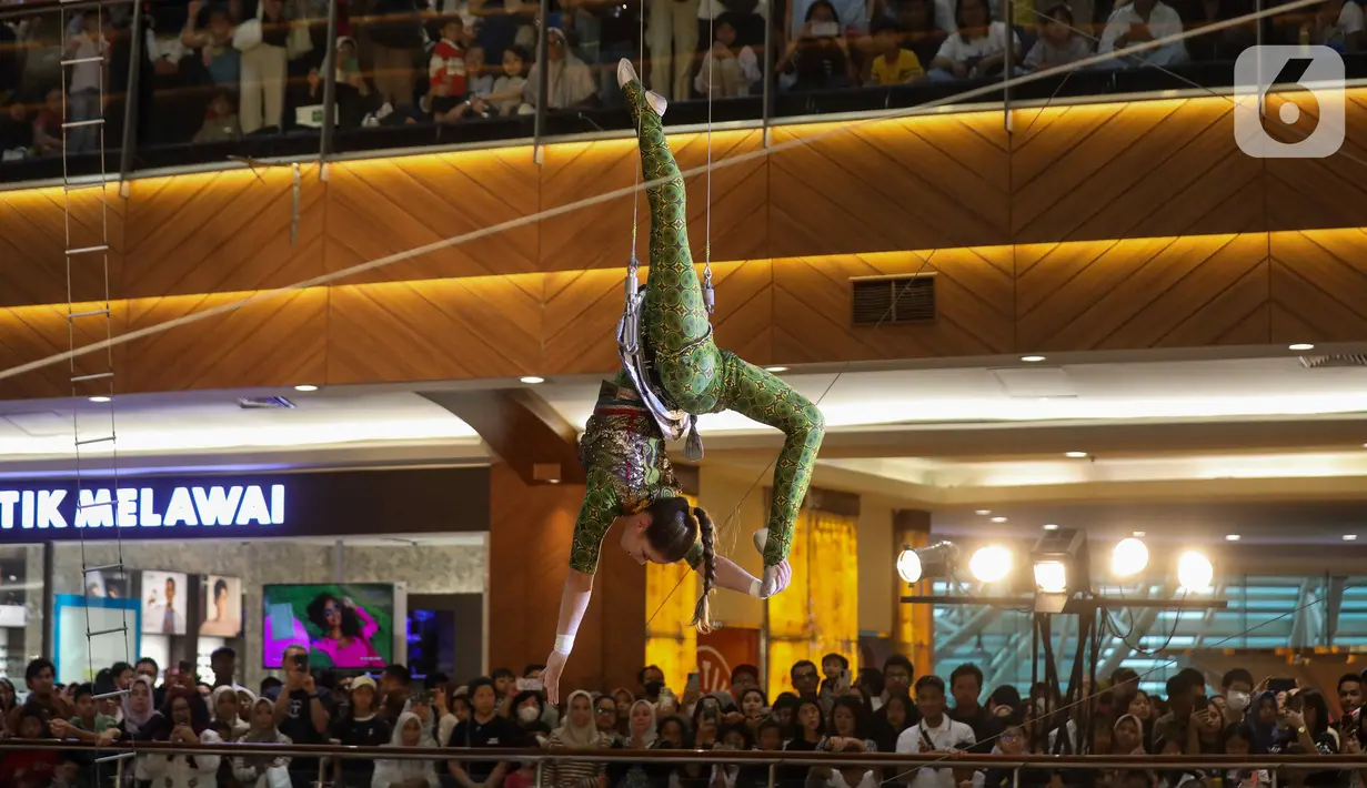 Personel grup sirkus asal Rusia The Nikolaevs melakukan atraksi akrobatik Flying Trapeze di Atrium Utama Mal Pondok Indah 2, Jakarta, Minggu (30/6/2024). (Liputan6.com/Herman Zakharia)