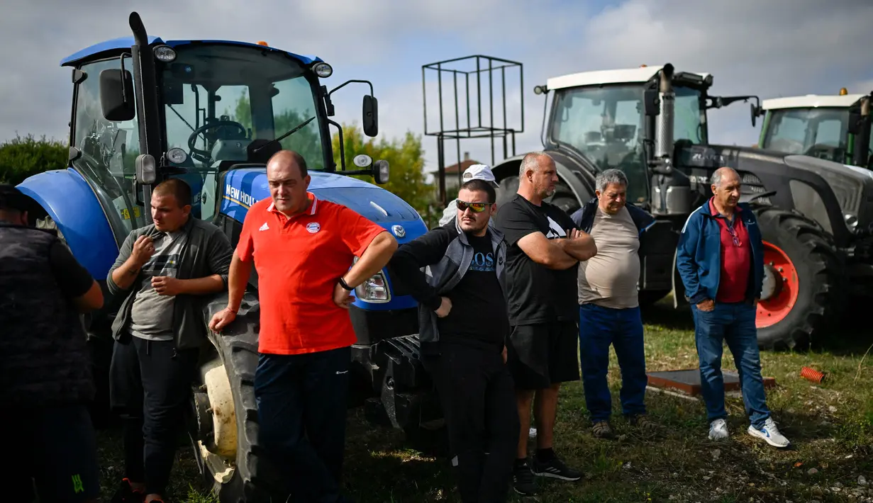 Para petani berdiri di depan traktor mereka dalam sebuah protes menentang pencabutan larangan impor biji-bijian yang berasal dari Ukraina, di Dolni Bogrov, dekat Sofia, pada tanggal 19 September 2023. (Nikolay DOYCHINOV/AFP)