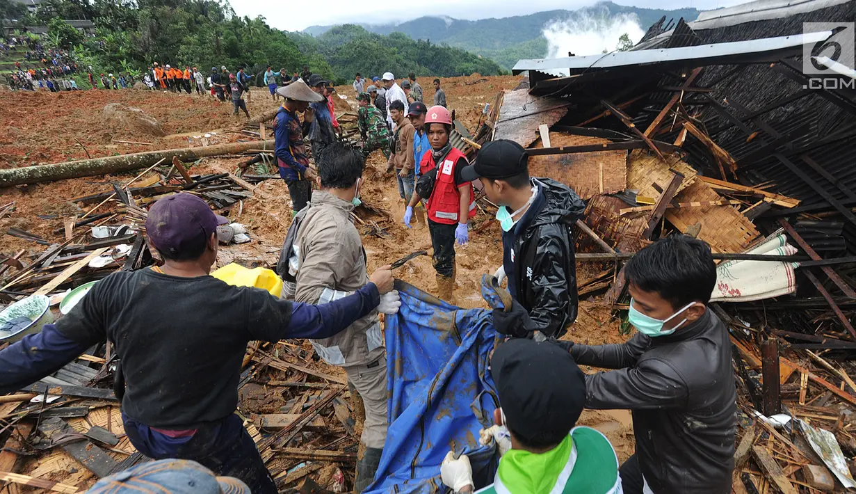 Tim SAR dibantu warga sekitar mengevakuasi jenazah korban longsor di Dusun Cimapag, Desa Sirnaresmi, Kecamatan Cisolok, Sukabumi, Selasa (1/1). Longsor mengakibatkan 30 rumah yang dihuni 107 jiwa tertimbun. (merdeka.com/Arie Basuki)