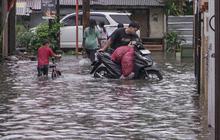 FOTO: Drainase Meluap, Warga Pasar Rebo Terobos Genangan