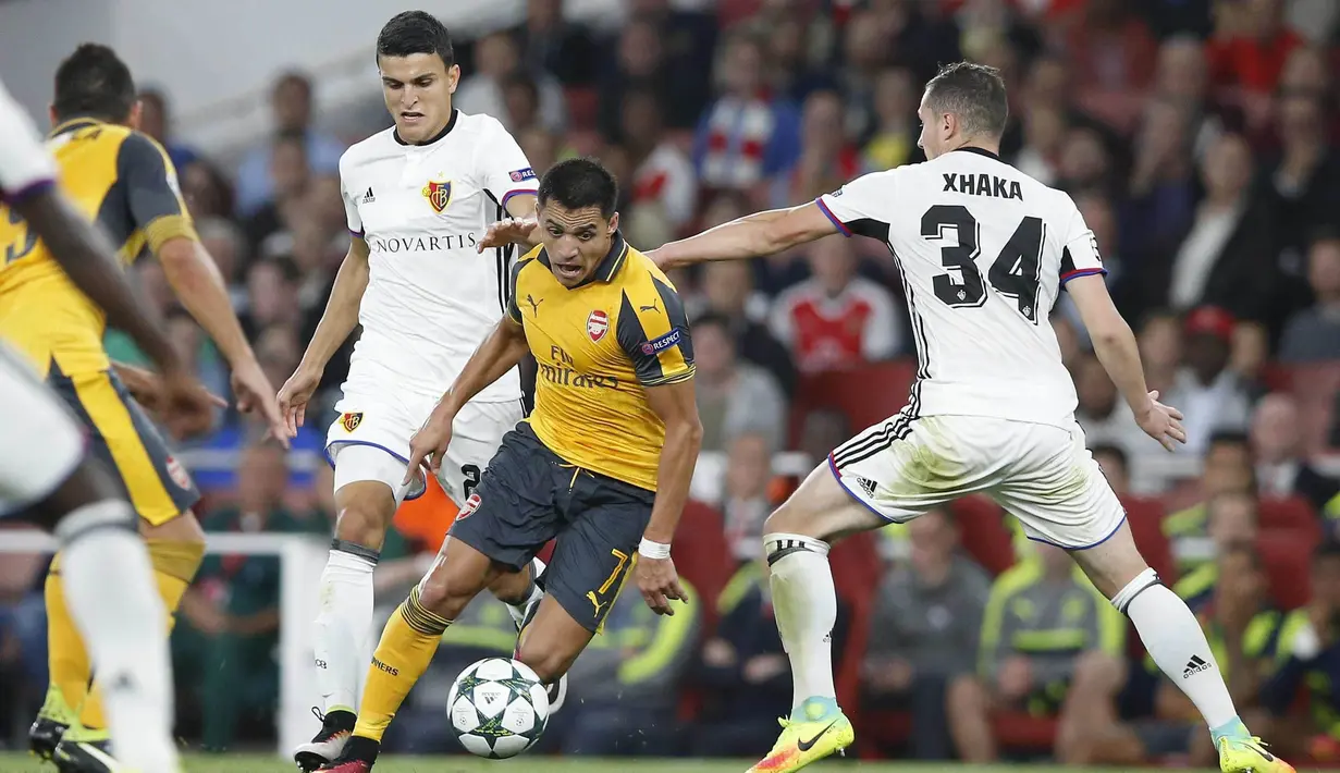 Penyerang lincah Arsenal, Alexis Sanchez mencoba melewati hadangan para pemain Basel pada laga grup A Liga Champions di Emirates stadium, London, Kamis (29/9/2016)dini hari WIB. (AP/Alastair Grant)