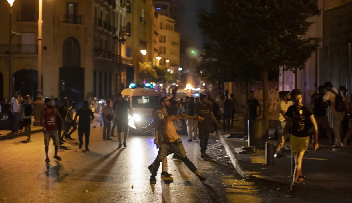 Pengunjuk rasa antipemerintah melempar batu dan bentrok dengan polisi antihuru-hara selama protes terhadap elite politik yang telah memerintah negara selama beberapa dekade di Beirut, Lebanon, Kamis (6/8/2020). (AP Photo/Hassan Ammar)