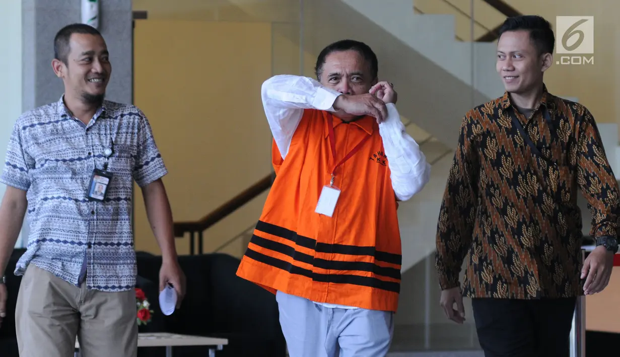 Gubernur Aceh Irwandi Yusuf (tengah) berusaha menutupi wajah usai menjalani pemeriksaan di Gedung KPK, Jakarta, Jumat (6/7). Ini merupakan pemeriksaan perdana setelah Irwandi ditahan oleh KPK. (Merdeka.com/Dwi Narwoko)
