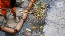 Petugas membersihkan sampah di sepanjang Kali Taman Anggrek, Jakarta, Rabu (8/7/2020). Banyaknya limbah menyebabkan Kali Taman Anggrek menjadi berwarna hitam dan berbau tidak sedap meskipun dibersihkan setiap hari. (Liputan6.com/Immanuel Antonius)