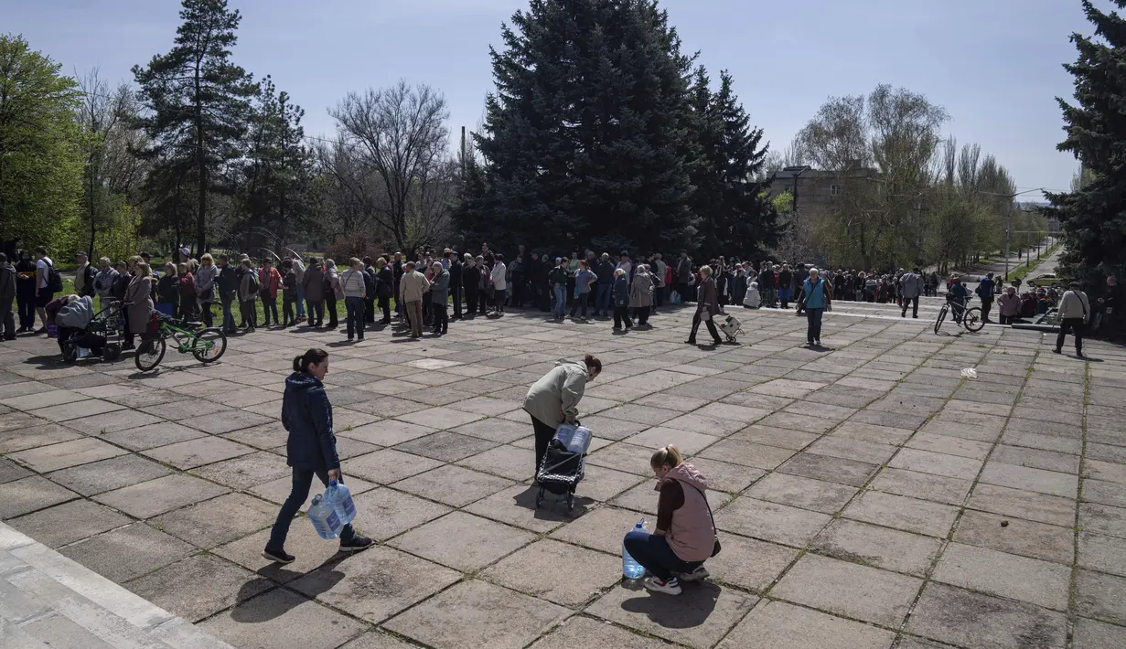 <p>Penduduk setempat mengantre untuk menerima air minum di pusat distribusi di Toretsk, Ukraina timur,pada 25 April 2022. Penduduk Toretsk tidak memiliki akses air selama lebih dari dua bulan karena perang Rusia Ukraina. (AP Photo/Evgeniy Maloletka)</p>