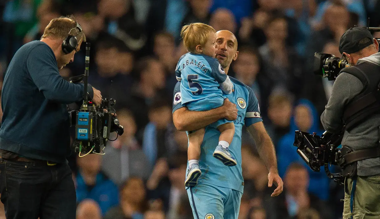 Bek Manchester City, Pablo Zabaleta, menggendong anaknya usai pertandingan Liga Inggris melawan West Bromwich Albion di Stadion Etihad, Selasa, (16/05/2017). Zabaleta resmi pamit dari klub Manchester City. (EPA/Peter Powell)