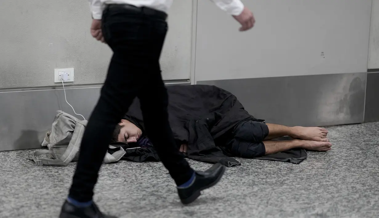 Beberapa memiliki selimut, tetapi banyak yang tidur langsung di lantai, berserakan di bandara dengan beberapa barang di dekat mereka. (AP Photo/Natacha Pisarenko)