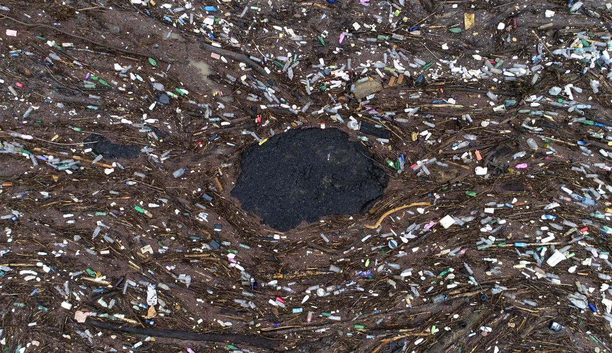 Sampah mengapung di sungai Drina dekat Visegrad, Bosnia, Jumat, 20 Januari 2023. Berton-ton limbah yang dibuang di tempat pembuangan sampah tepi sungai yang tidak diatur dengan baik atau langsung ke sungai-sungai di tiga negara Balkan Barat akhirnya menumpuk selama musim air tinggi di musim dingin dan musim semi, di belakang penghalang sampah di Sungai Drina, Bosnia timur. (AP Photo/Armin Durgut)