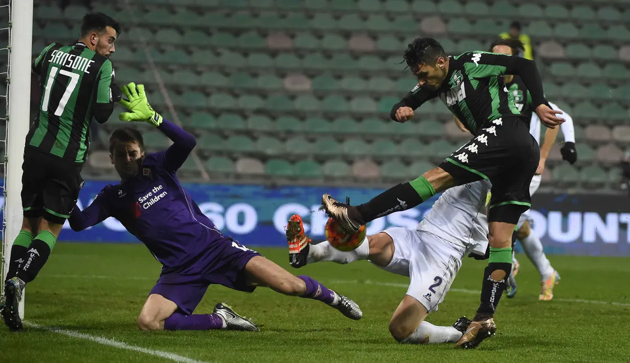 Pemain Sassuolo, Sergio Floccari  (kanan) melepaskan tembakan ke arah kiper Fiorentina, Ciprian Anton Tatarusanu pada lanjutan liga Italia Serie A di Stadion Mapei, Reggio Emilia, Selasa (01/12/2015). (AFP Photo/Olivier Morin)