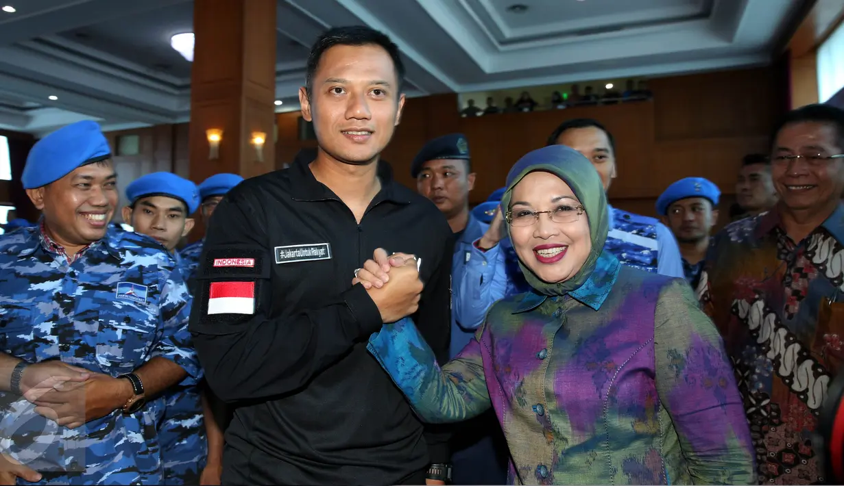 Agus Harimurti Yudhoyono dan Sylviana Murni melakukan salam komando saat menghadiri acara konsolidasi pengurus Partai Demokrat dan relawan pasangan cagub-cawagub DKI, Agus-Sylviana, di kawasan Pramuka, Jakarta, Rabu (5/10). (Liputan6.com/Johan Tallo)