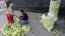 Peningkatan produksi ini menjadi bagian kebutuhan bahan pelengkap hidangan khas lebaran. Tampak dalam foto, pedagang menyelesaikan produksi kulit ketupat lebaran di Pasar Pondok Labu, Jakarta, Rabu (18/3/2026). (merdeka.com/Arie Basuki)