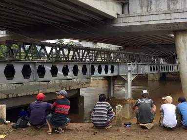 Warga berkumpul untuk memancing ikan dari Sungai Ciliwung yang meluap di Rawajati,Jakarta, Selasa (6/2). Banyak ikan yang hanyut terbawa arus banjir Sungai Ciliwung. (Liputan6.com/Immanuel Antonius)