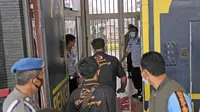 Staf dan petugas polisi menjaga pintu masuk utama Lapas Kelas I Tangerang Banten, setelah kebakaran, Rabu (8/9/2021). Selang dua jam lebih kemudian, api yang membakar Lapas Kelas I Tangerang baru bisa dipadamkan oleh petugas. (AP Photo/Dita Alangkara)