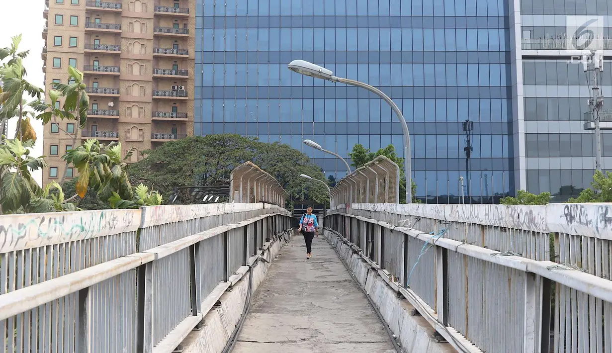 Pejalan kaki melintasi jembatan penyeberangan orang tanpa atap dan tidak terawat di Jalan TB Simatupang, Jakarta, Rabu (10/10). Kondisi tersebut menyebabkan JPO terkesan kumuh serta mengurangi kenyamanan pejalan kaki. (Liputan6.com/Immanuel Antonius)