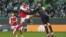 <p>Pemain Arsenal, Reiss Nelosn (kiri) berebut bola dengan kiper Sporting CP, Antonio Adan pada laga leg pertama Liga Europa 2022/2023 di Jose Alvalade Stadium, Lisbon, Jumat (10/03/2023) dini hari WIB. Laga berakhir dengan skor imbang 2-2. (AP Photo/Armando Franca)</p>